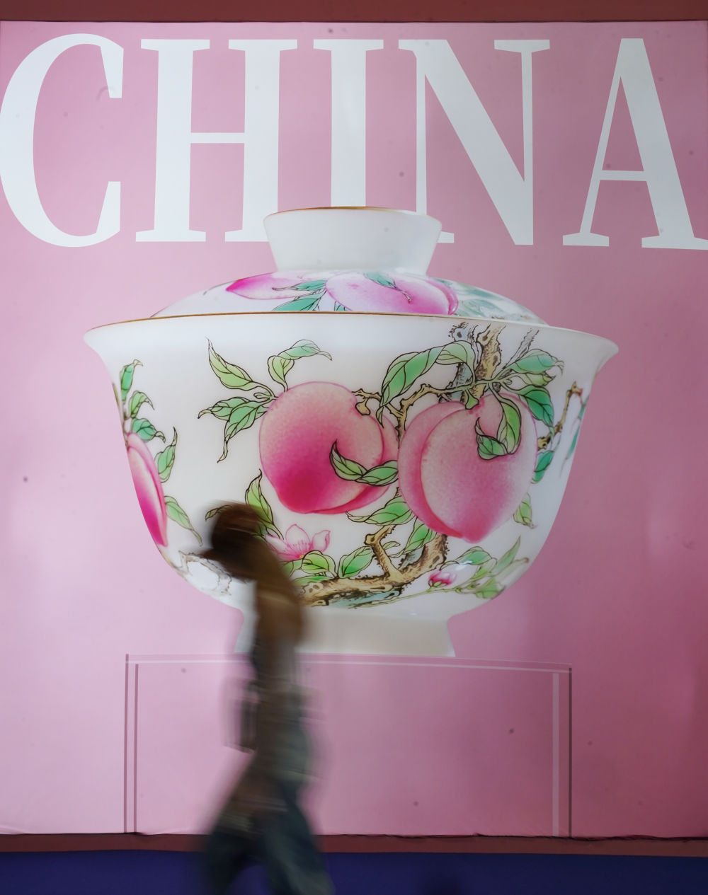 　　2025年10月18日，在中国景德镇国际陶瓷博览会现场，参观者从景德镇瓷器的海报前走过。新华社记者 周密 摄
